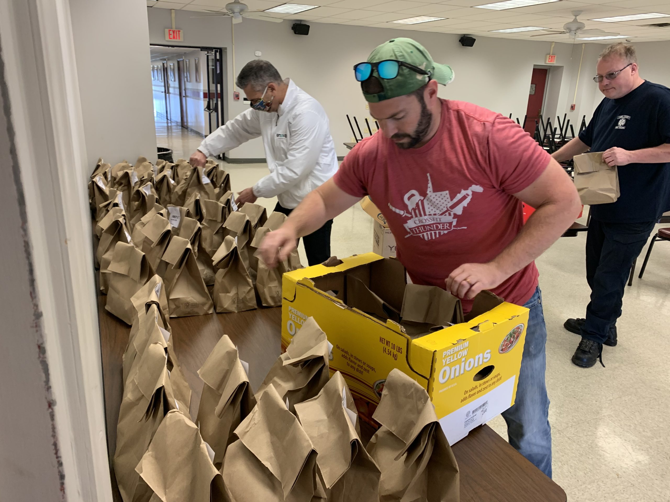 (Left to right) Toney Stroud, an attorney with Encova Insurance and Chair of the Huntington Regional Chamber, joins Drew Hines, owner of Butter It Up in Downtown Huntington, as they deliver boxed lunches to Cabell County EMS workers. 